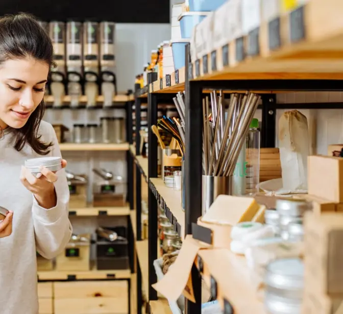Mulher a cheirar produto numa loja de produtos a granel ou ecológicos