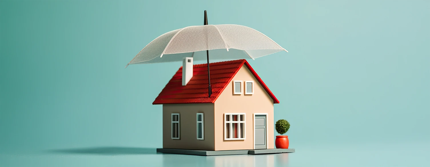 miniature house with an umbrella protecting it