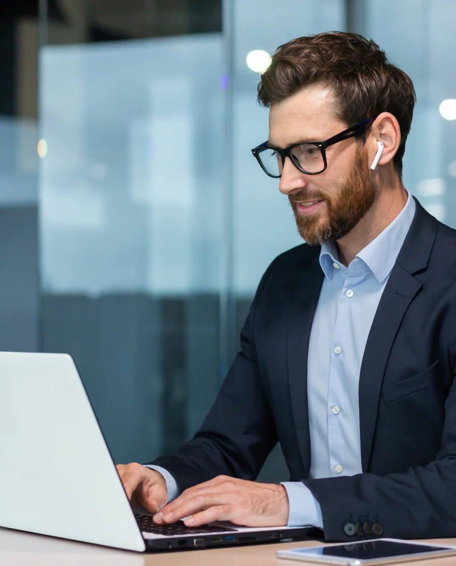 homem com óculos e auricular, a trabalhar num computador
