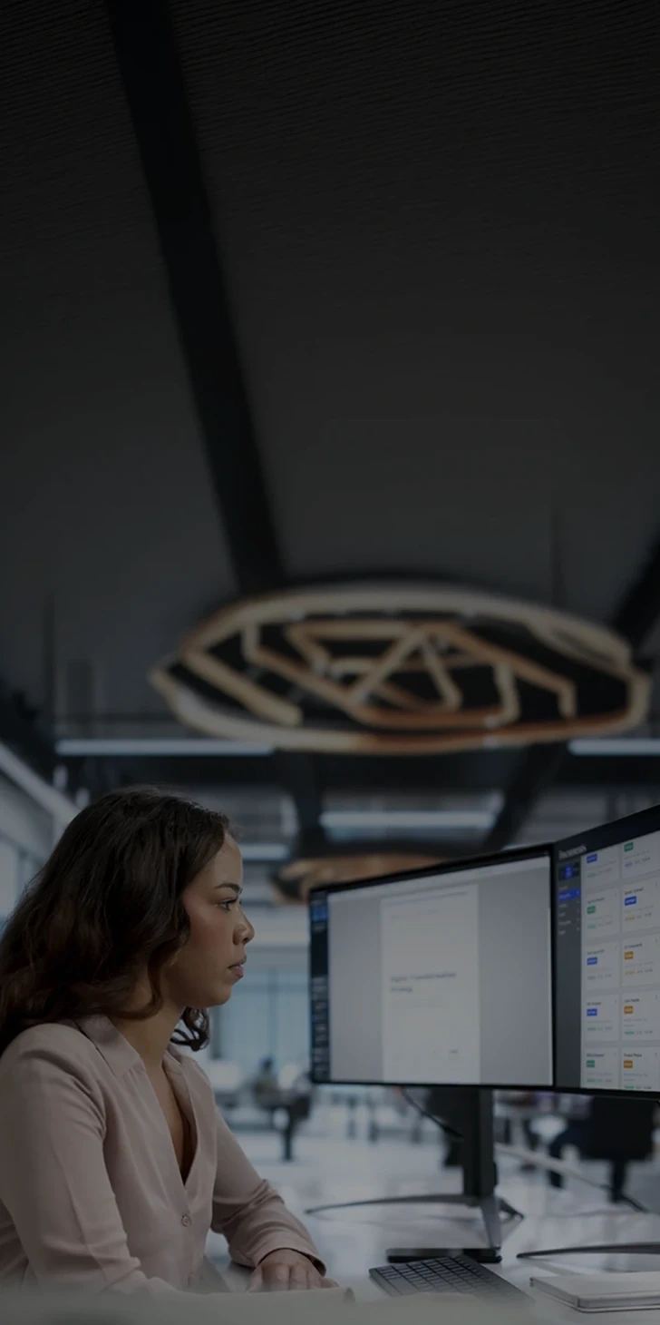 Woman working in front of two monitors in an office