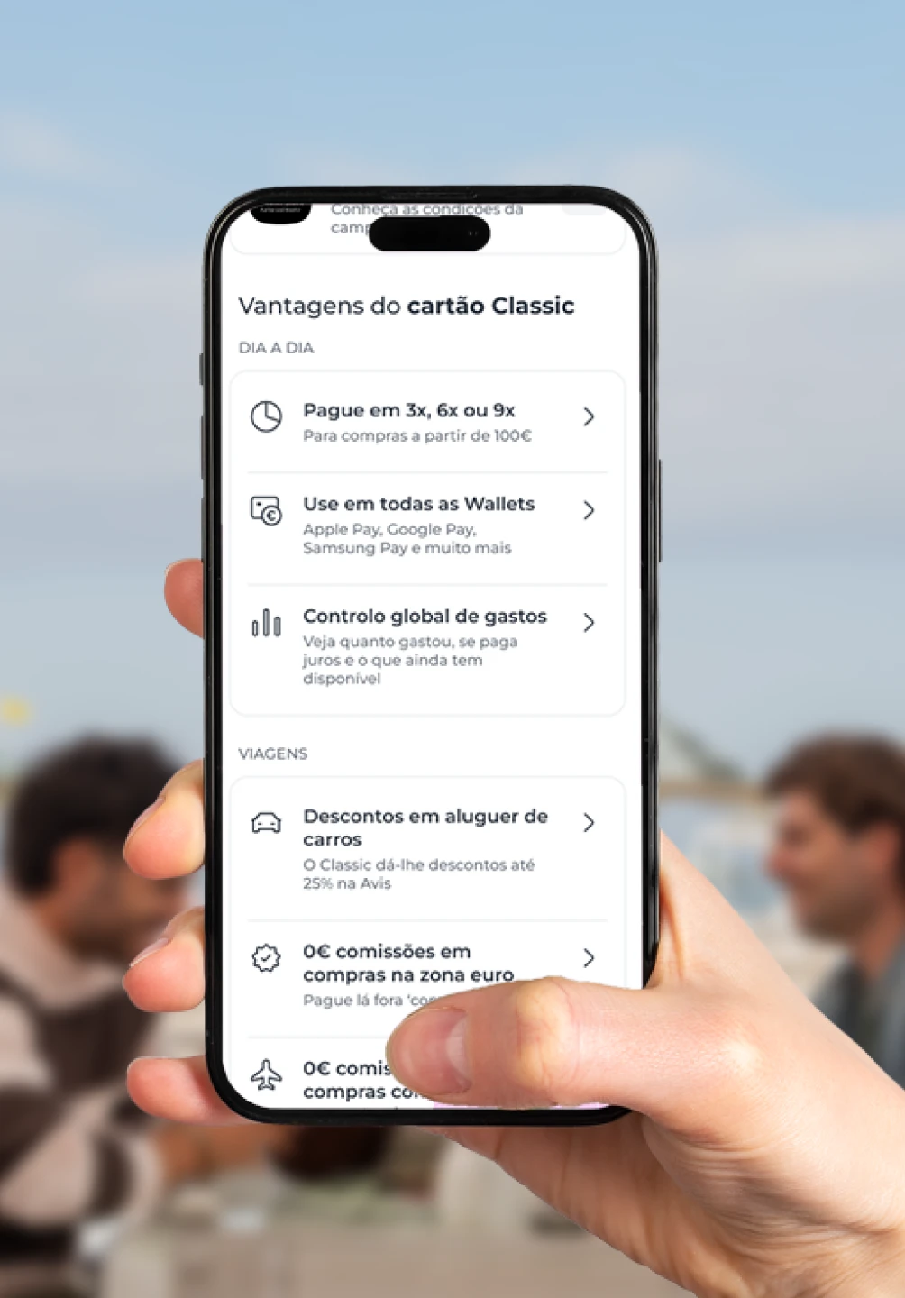 Mão a segurar um smartphone que mostra o ecrã da App Millennium com as vantagens do cartão Classic