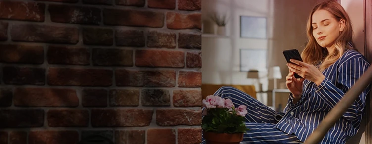 lady sitting by the window, with a phone in her hand