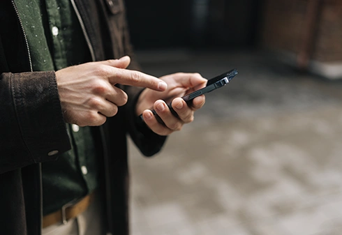 A man's hands using a smartphone to perform an operation