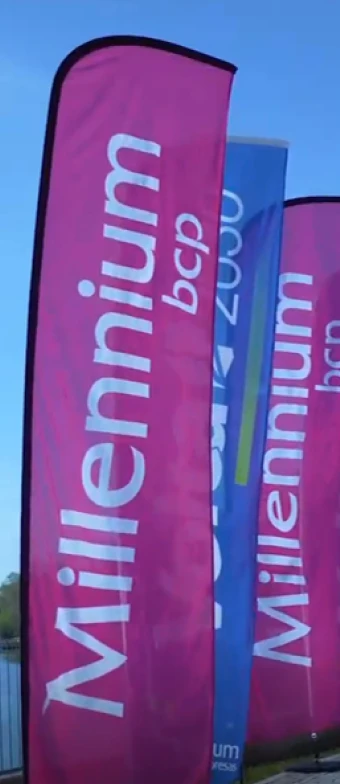 4 bandeiras verticais com os logotipos "Millennium bcp" e "Volta Portugal 2030"