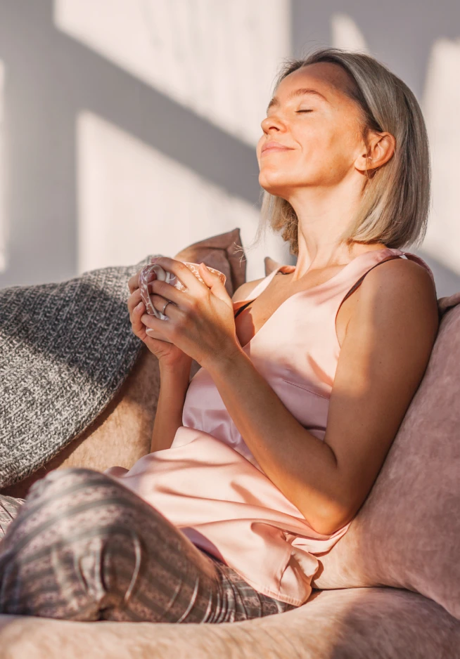 senhora no sofá, a relaxar, com chávena na mão