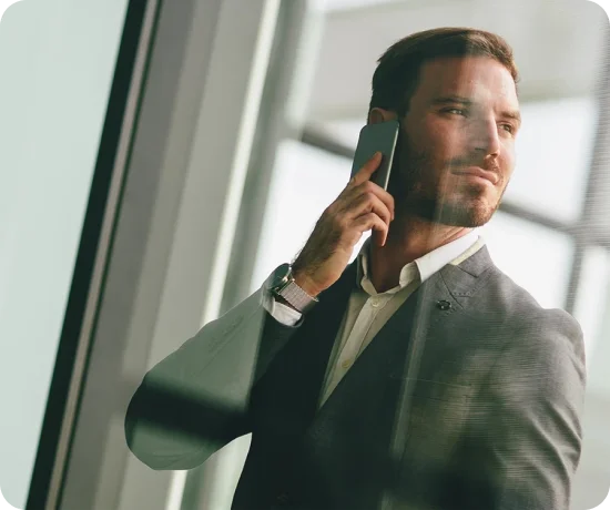 Homem de fato e gravata, a falar ao telemóvel, a olhar para o lado